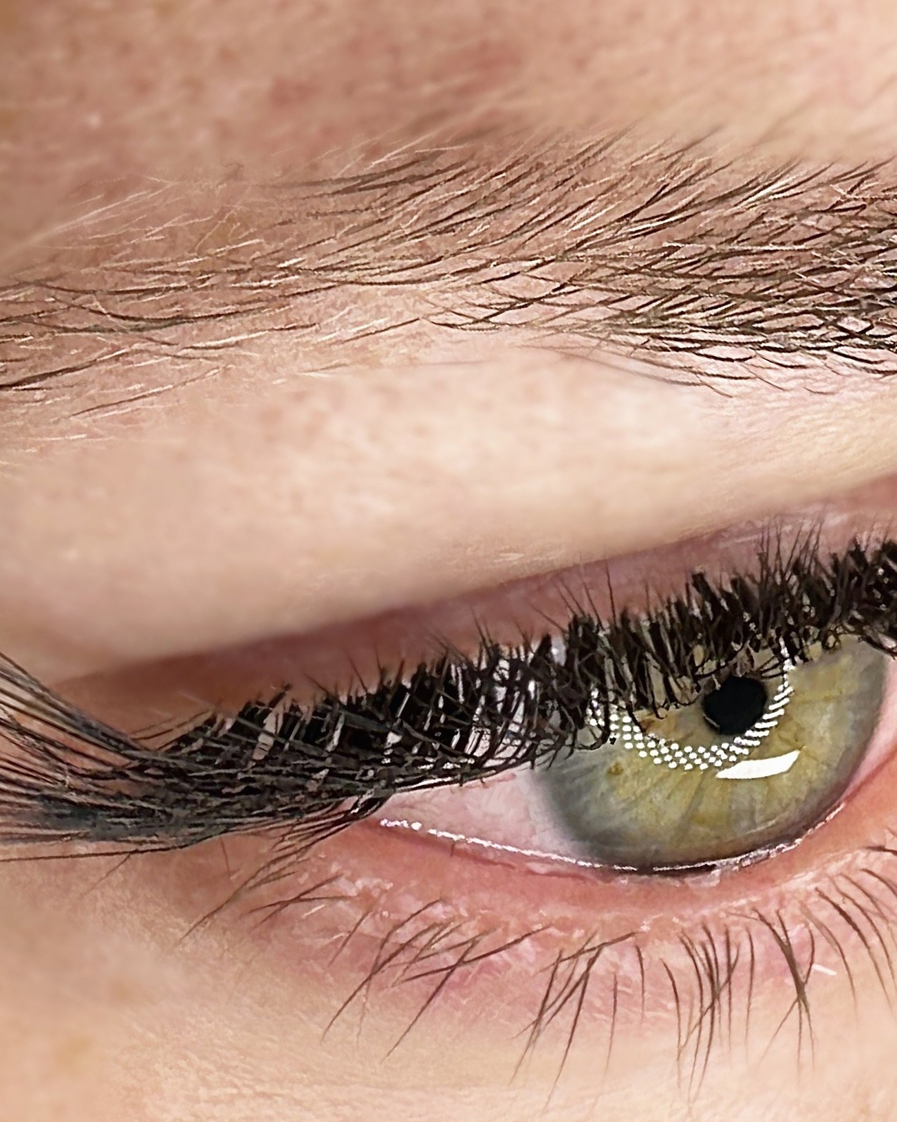 Wimperextensions op een groen oog, close-up van het gezette resultaat