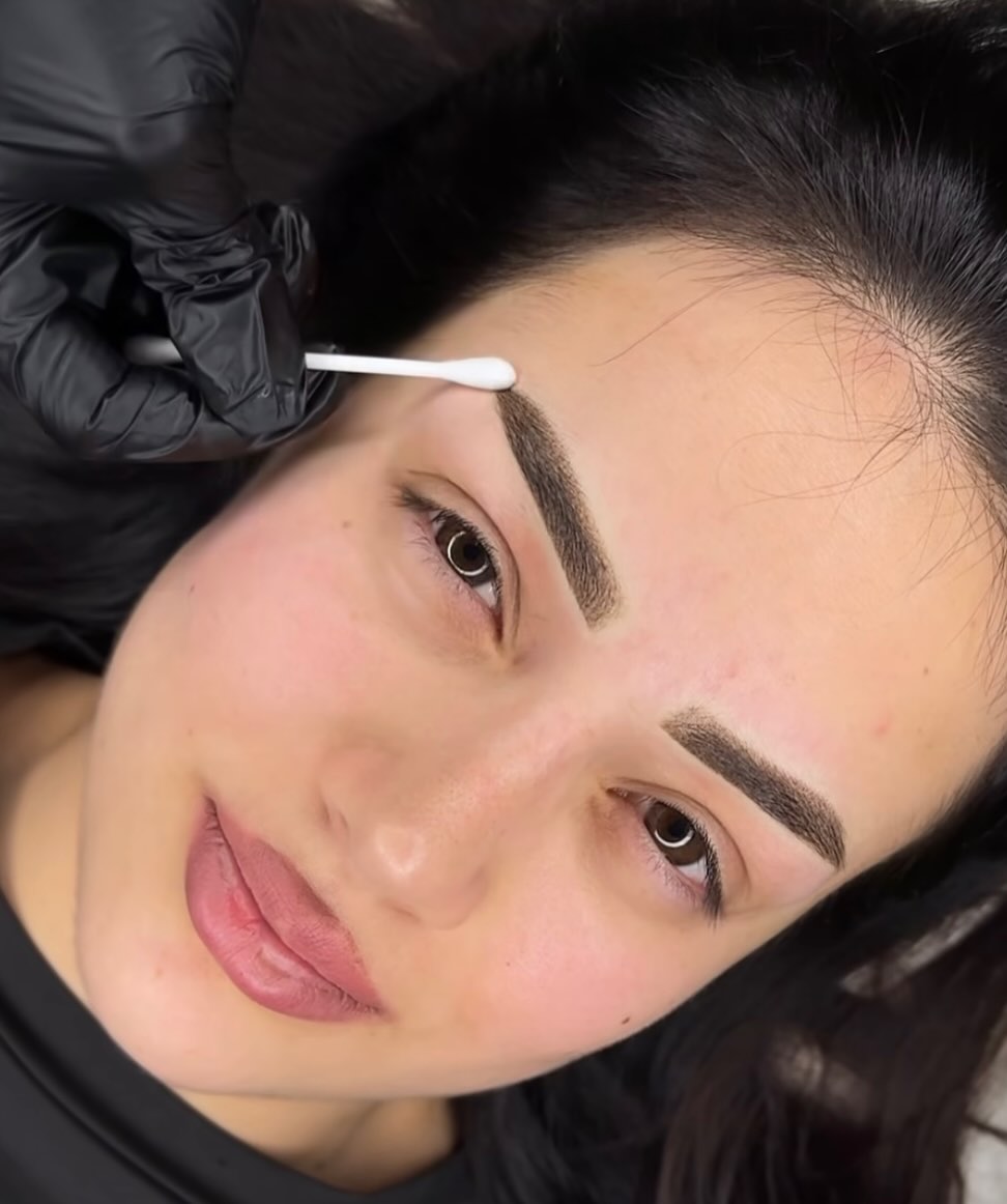 Klant met verse powderbrows, de wenkbrauw wordt afgewerkt met een wattenstaafje